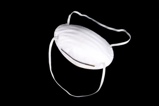 A mask to protect against swine flu, bird flu, bio weapons or radiation, isolated on black studio background.