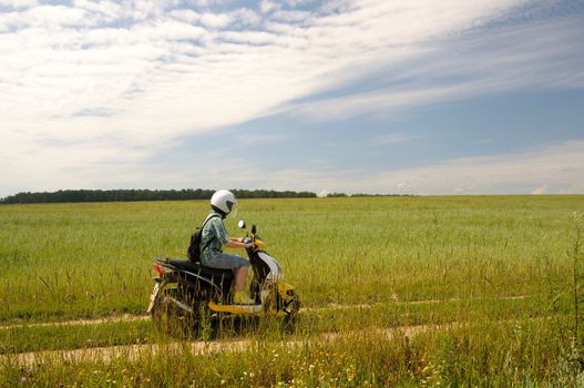 girl on a scooter on a country road