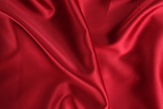 A background of a crumpled red satin cloth.