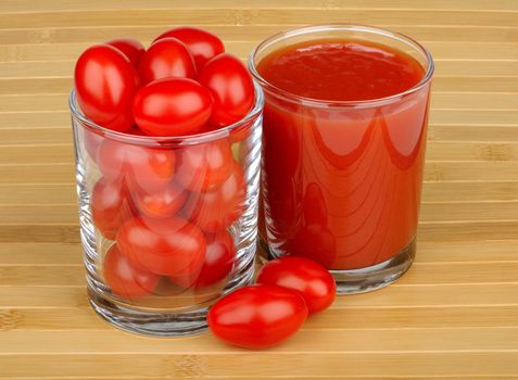 tomato juice and tomatoes on wooden background