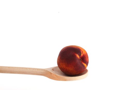 Apple on a wooden spoon isolated against a white background