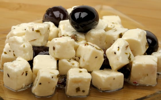 cheese and olives in oil on a plate