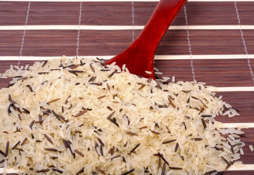 mixture of purified and wild rice with a wooden spoon on the mat
