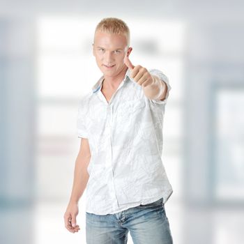 Young casual man portrait doing the thumbs up sign in a white background