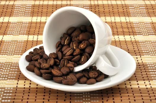 white cup with coffee beans on the mat