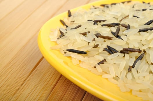 raw white and wild rice on a yellow plate