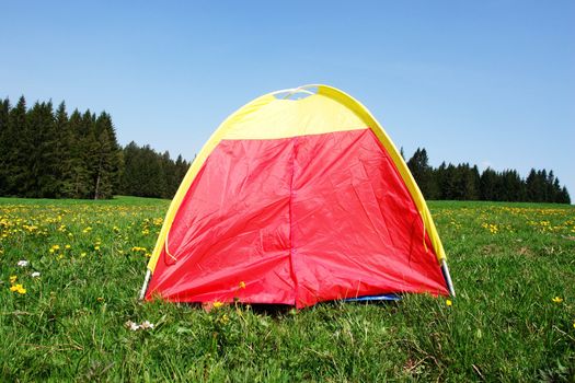 A colourful tent in the meadow outside