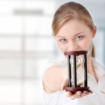Young business woman with hourglass - time concept