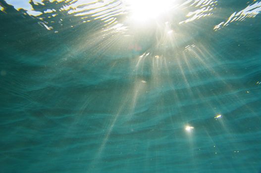 sun rays shines through water surface in the red sea