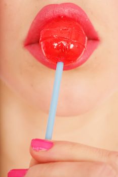 close-up of a red lollipop on pink lips