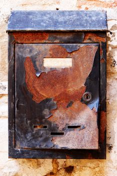 Old rusty mailbox on the shabby gate in Italy