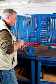 Experienced car mechanic in action at a work-bench