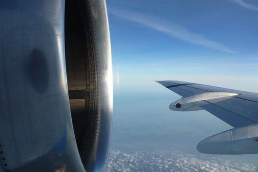 Flying plane wing and motor in a deep blue sky