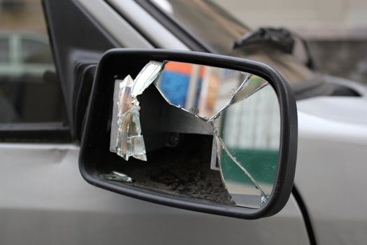 Close up of a broken rear mirror on the siade of a grey car