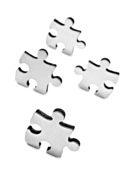 Stainless steel puzzle pieces on white background with space for text