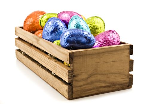 Colorful easter eggs in wooden box on white background