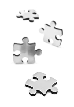 Stainless steel puzzle pieces on white background with space for text