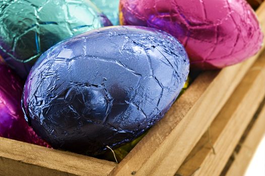 Colorful easter eggs in wooden box on a white background