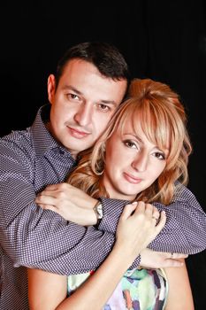 Couple in love smiling. Over black background