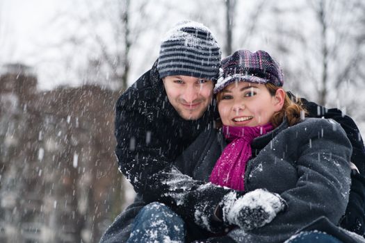 Happy couple in the snow having some fun together