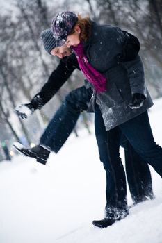 Happy couple in the snow having some fun together