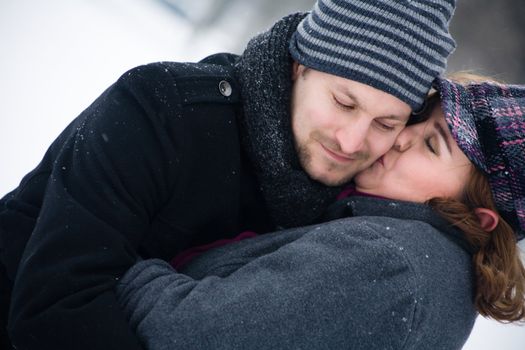 Happy couple in the snow having some fun together