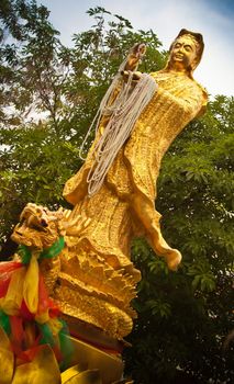 Kuan Yin the avartar of next Buddha statue in gold with pearl lace  from the servants in her hands, Korat, Thailand.