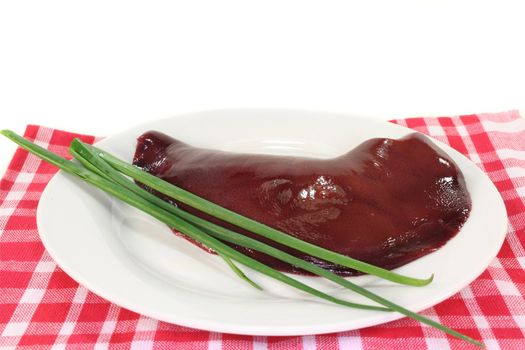 raw liver and chives on a white plate