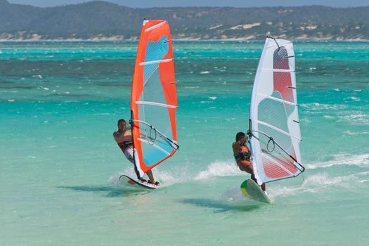 Couple man and woman windsurfing in the lagoon