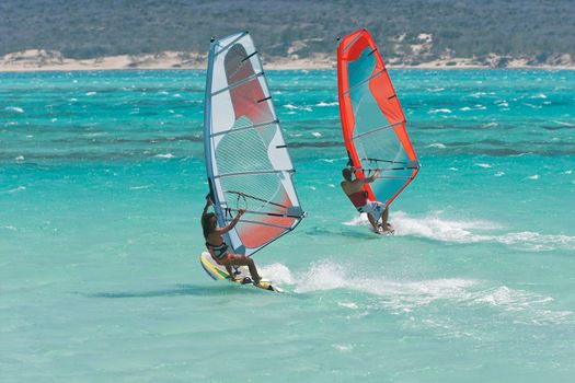 Couple man and woman windsurfing in the lagoon