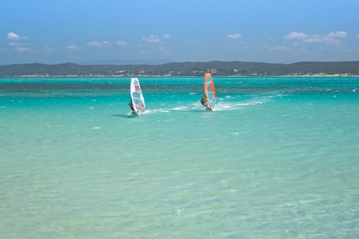 Couple man and woman windsurfing in the lagoon