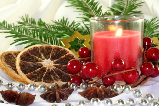 a burning candle with Christmas decorations