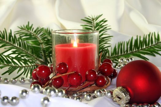 a burning candle with Christmas decorations