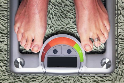 Bathroom scales isolated against green carpet