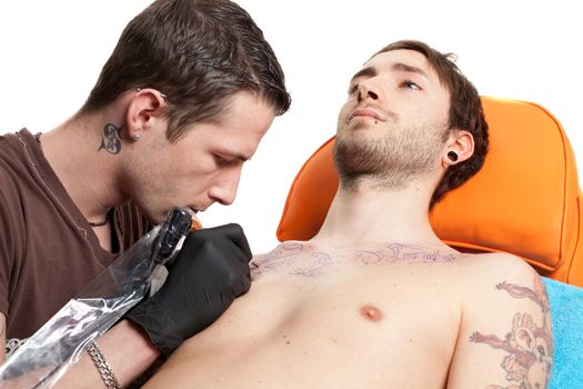 a horizontal shot of a tattoo artist at work