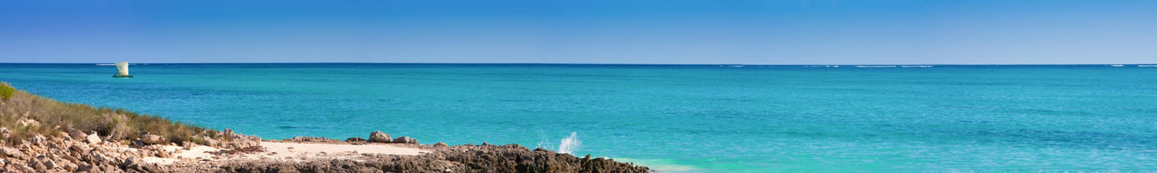 Lagoon panorama with rocks and fishing boat sailing