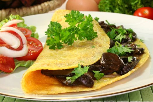 an omelet stuffed with wild mushrooms and fresh salad