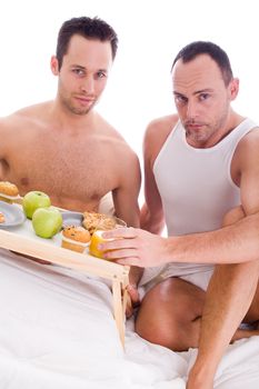 A Happy homo couple and their breakfast on a tray in bed
