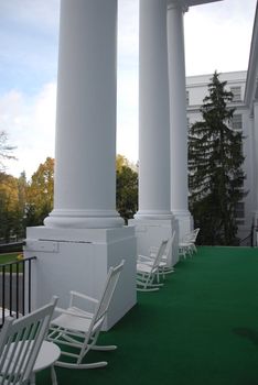 Rocking chairs on a big porch looking over the lawn