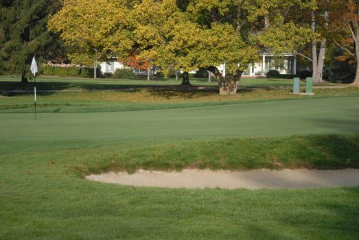 A view a flag on a golf course near a bunker