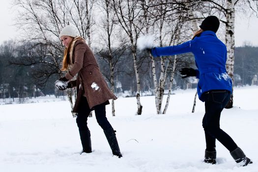 two sisters having a snow ball fight