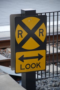 A railroad sign at a train crossing in the city
