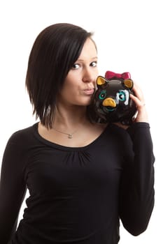 a young woman kissing a piggy bank on her shoulder isolated on white