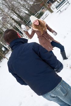 Young couple in a snow field playing