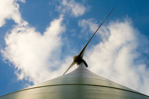 Wind turbine, a bottom view, against the background of the cloudy sky