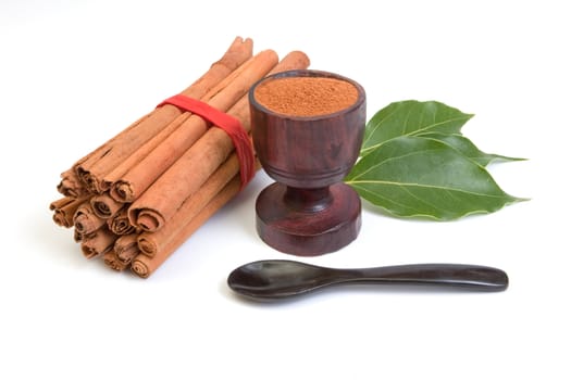 Bundle of cinnamon with powder and leaves