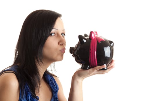 a young woman kissing a piggy bank isolated on white