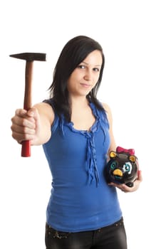 a young woman holding a piggy bank and a hammer isolated on white