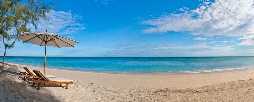 Panorama deckchair and parasol on the white sand beach facing the lagoon