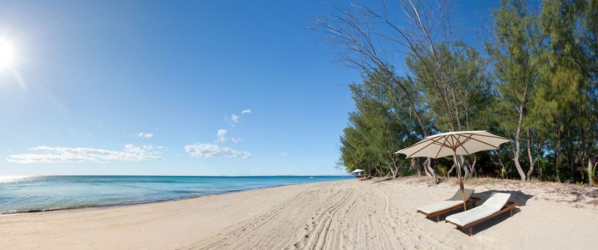 Panorama deckchair and parasol on the white sand beach facing the lagoon